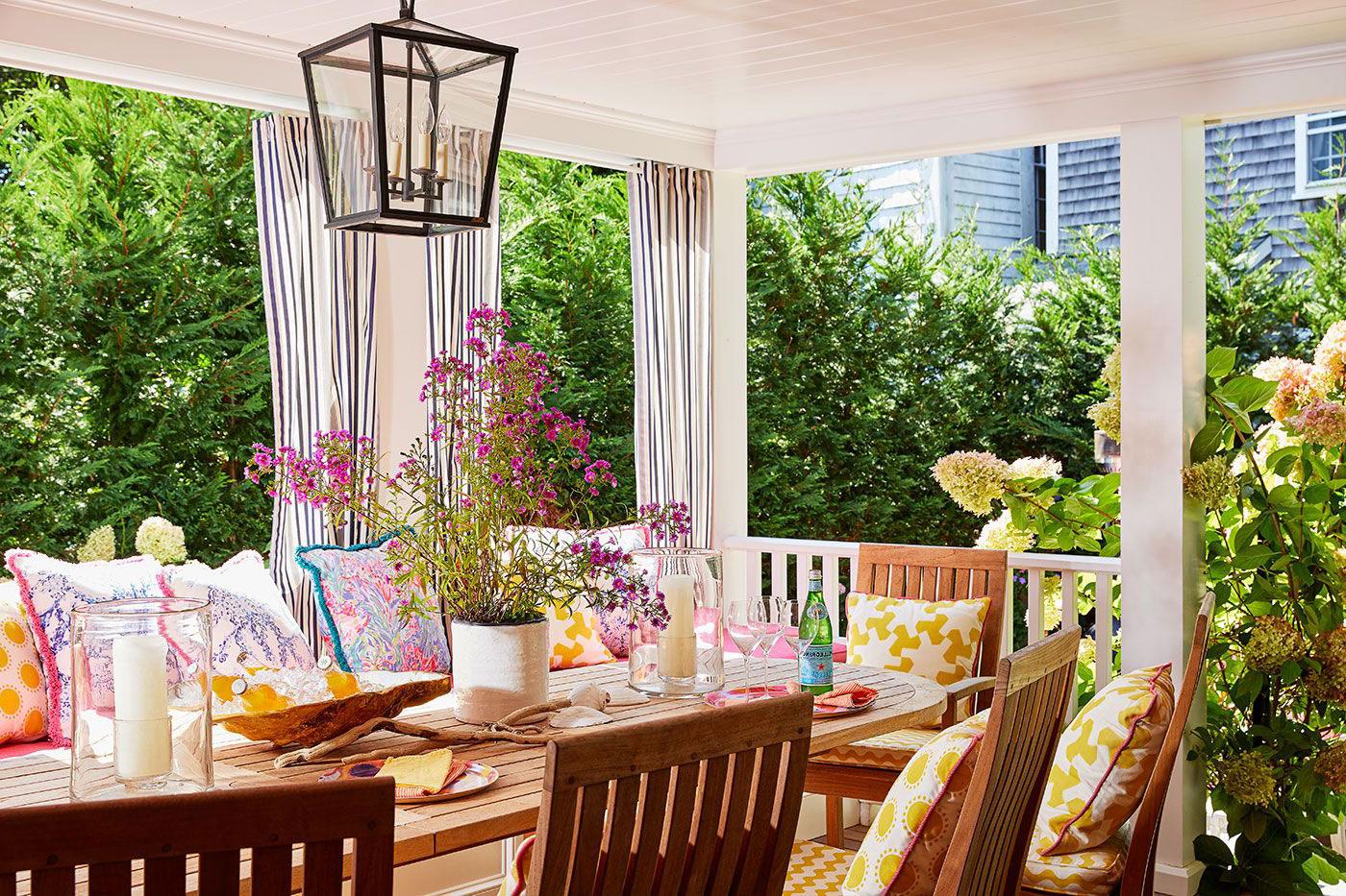 Porch with table and chairs surrounded by lush plantings
