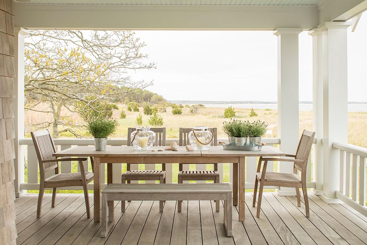 Teak table and chairs on a deck overlooking the ocean and marsh